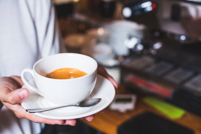 human-hand-holding-cup-coffee-cafeteria